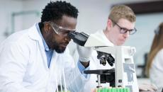 Lab worker looking through microscope