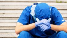 Medical worker with head in hands