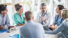 A multidisciplinary team of hospital staff holding a meeting