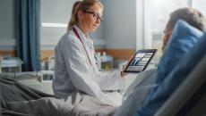 Healthcare worker showing tablet to patient