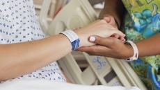 Patient holding healthcare worker's hand