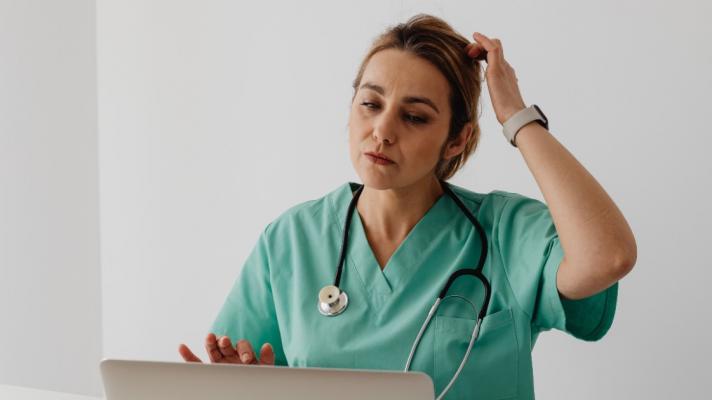 A person in scrubs on the computer