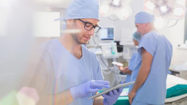 Medical worker in scrubs using a tablet