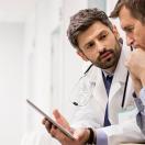 Doctor and person in shirt looking at tablet