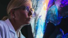 Person in lab coat looking at computer display