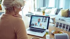 A person in home is having a telehealth appointment with a doctor via laptop.