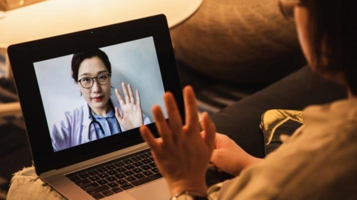 A person looks at a doctor on a screen