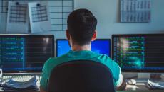 Healthcare worker looking at multiple monitors