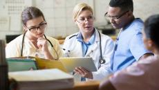 Doctors and nurses discussing a patient's chart from a digital tablet 