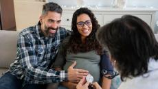 Pregnant couple talking to doctor