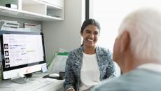 A smiling doctor facing a patient in a consultation