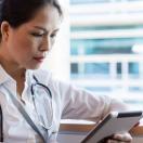 A doctor checking a patient's record on a digital tablet