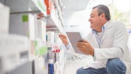 A pharmacist doing an inventory using a digital tablet.