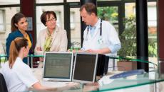 Hospital staff in a discussion around the nurses station