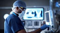 A surgeon checking a monitor in the operating room