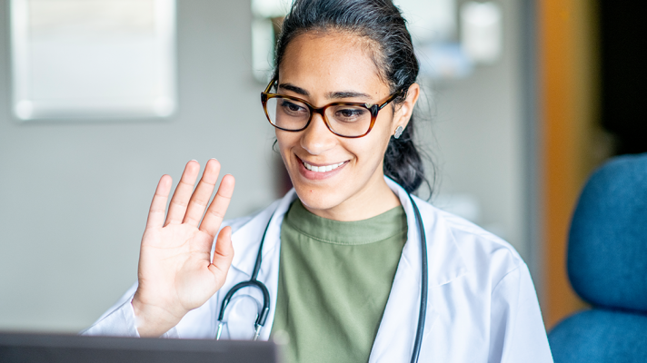 Person in medical garb doing a virtual visit via telehealth